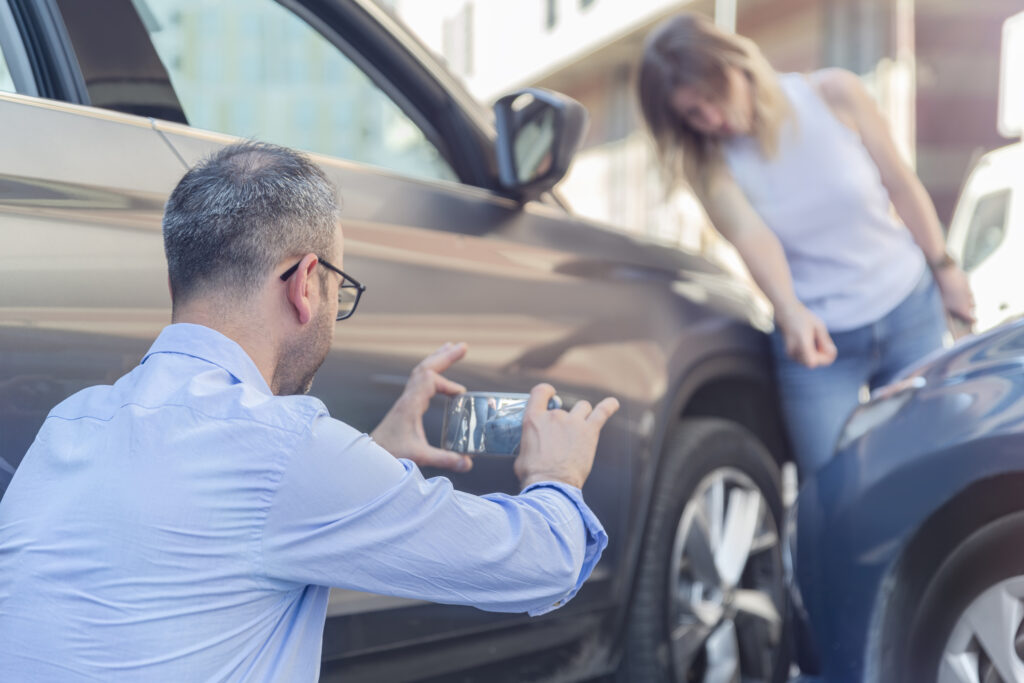 A man taking a photo of a car accident.